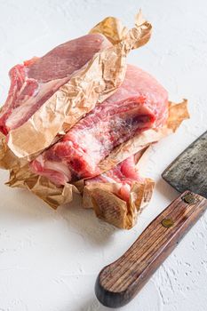 Raw organic bio Pork Belly grill. side view Vertical. with meat butcher cleaver on white stone background.