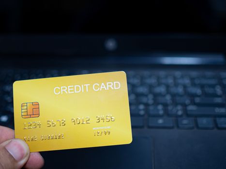 Online shopping concept. Close-up human hands holding a credit card on notebook background.