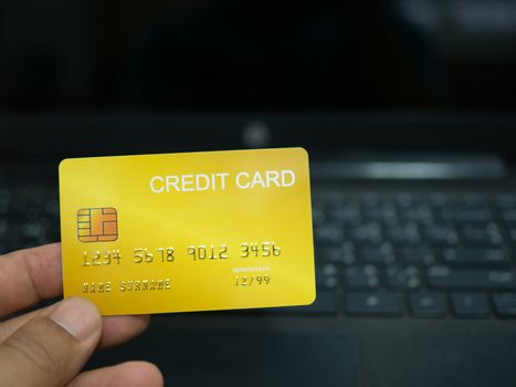 Online shopping concept. Close-up human hands holding a credit card on notebook background.