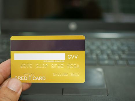 Online shopping concept. Close-up human hands holding a credit card on notebook background.