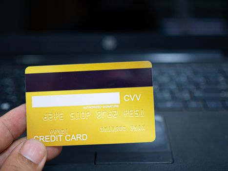 Online shopping concept. Close-up human hands holding a credit card on notebook background.