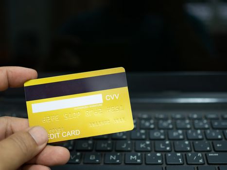 Online shopping concept. Close-up human hands holding a credit card on notebook background.