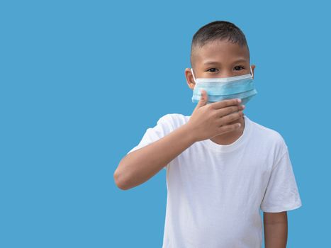 Boy wearing a protective mask And put his hand on his mouth On a blue background. New normal concept.