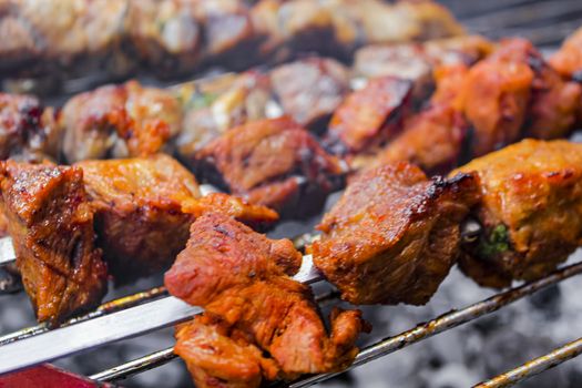 Russian shashlik with skewers on a round grill in Norway.