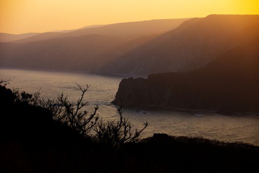 The rays of the setting sun make their way through the rocky coast of the reserve