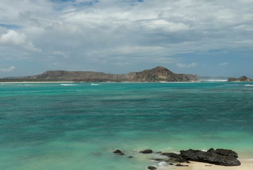 Aerial shot of Tanjung Aan Beach in Lombok, West Nusa Tenggara. Top tourist destination in Indonesia. Huge closed bay with turquoise water.