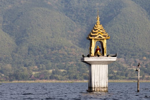 Fishermen's Buddhist shrine water level marker Inle Lake Myanmar . High quality photo