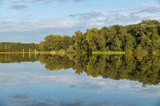 reflection of the trees in the lake of national park the iron man in Weert in Holland,this is in summer a place to swim and watersport