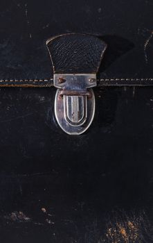 Detal of old metal bag press push lock , old black leather bag with yellow thread, rusty metal