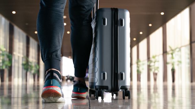 traveler with suitcase walking with carrying luggage and passenger for tour in the airport terminal for air traveling