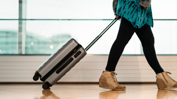 traveler with suitcase walking with carrying luggage and passenger for tour in the airport terminal for air traveling