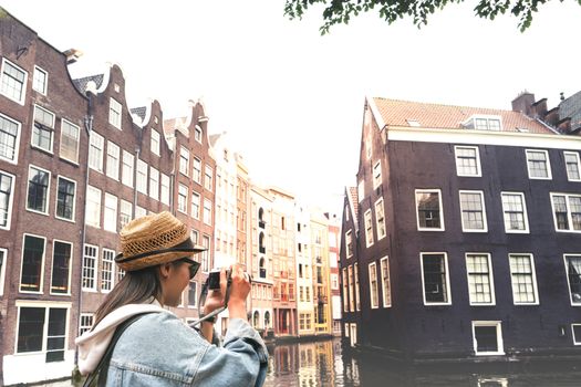 Outdoor lifestyle portrait of pretty young woman having fun in the city in Europe with digital camera travel photo of photographer Making pictures in hipster style