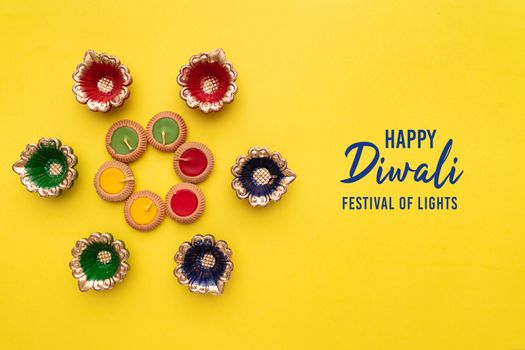 Happy Diwali - Clay Diya lamps lit during Dipavali, Hindu festival of lights celebration. Colorful traditional oil lamp diya
