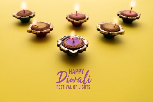 Happy Diwali - Clay Diya lamps lit during Dipavali, Hindu festival of lights celebration. Colorful traditional oil lamp diya