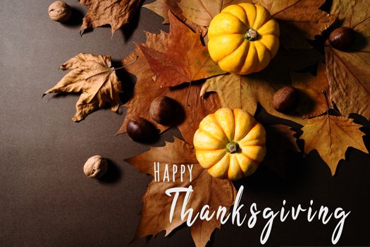 Happy Thanksgiving Day with pumpkin and maple leaves