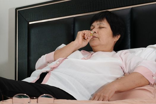 senior woman with headhache dizziness and smelling salts