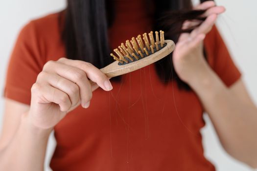 long loss hair on woman brush with and woman looking at her hair