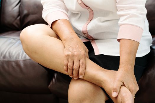 leg cramp, senior woman suffering from leg cramp pain at home, health problem concept