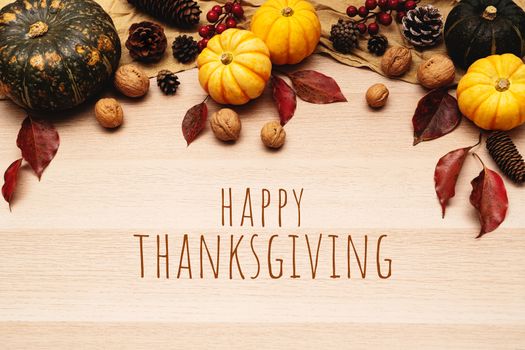 Happy Thanksgiving Day with pumpkin and nut on wooden background