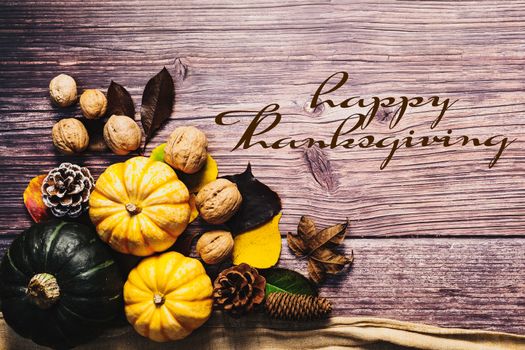 Happy Thanksgiving Day with pumpkin and nut on wooden table