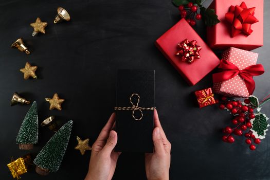 Hand holding christmas present in xmas decoration background