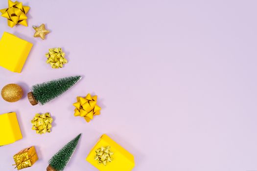Christmas decoration. Gifts, yellow and golden decorations on purple background. Christmas, winter, new year concept. Flat lay, top view, copy space