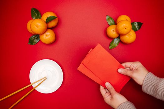 Flat lay Chinese lunar new year traditional food and offering red envelope on table top