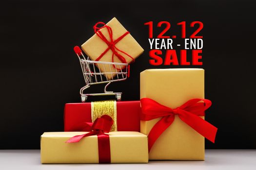 12.12 year-end sale concept, shopping cart and gift box on black background