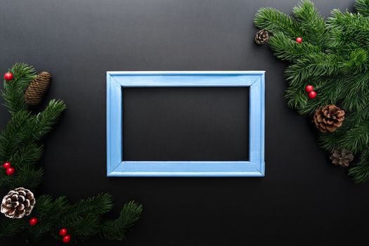 Christmas pine tree and photo frame with xmas decoration on black background