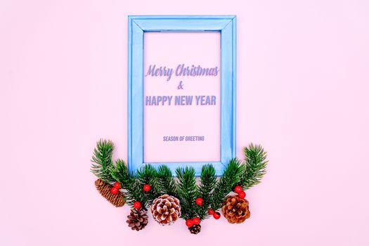 Christmas pine tree and photo frame with xmas decoration on pink background