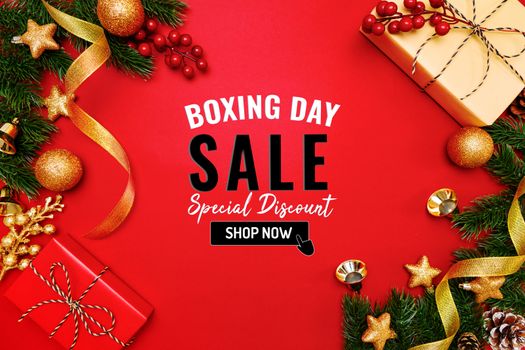Boxing day sale with Christmas present and xmas decoration on red background