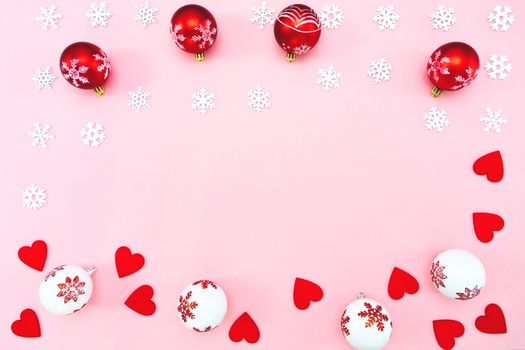 Christmas composition. Christmas balls, red heart and snowflakes decorations on pink background. Flat lay, top view, copy space