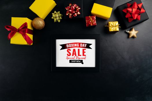 Boxing day sale with Christmas present and xmas decoration on black background