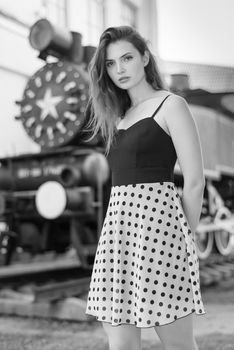 Beautiful girl in a white-black dress with polka dots.