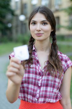 Young girl holding a condom. Protected sex