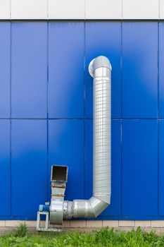 industrial grade air extraction duct with electrical motor on blue wall.