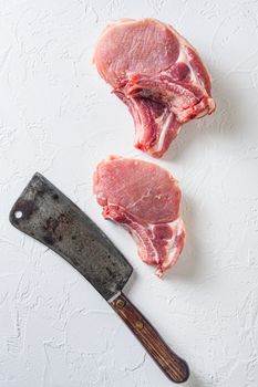 Organic bio Raw pork cutlet , fillets for grilling, baking or frying, Fith butcher cleaver ower textured white background. Overhead view.