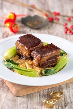 Dong Po Rou (Dongpo pork meat) in a beautiful blue plate with green broccoli vegetable, traditional festive food for Chinese new year cuisine meal, close up.