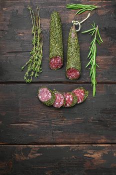 Traditional sausage salami fuet, cut to slices on old wooden table, flat lay with copy space.