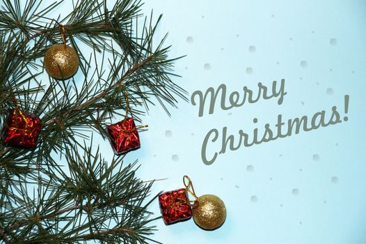 coniferous branches, Christmas tree decorations, text Merry Christmas on a New Year's blue background.