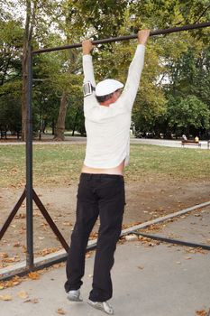 man is engaged on a horizontal bar in the park.