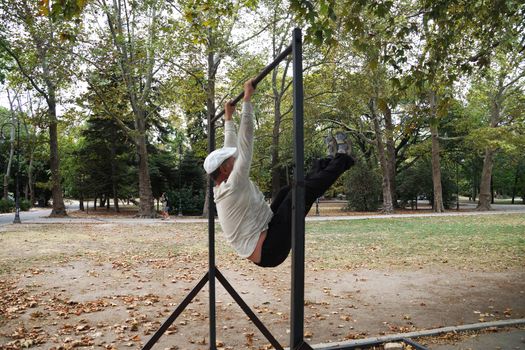 man is engaged on a horizontal bar in the park.