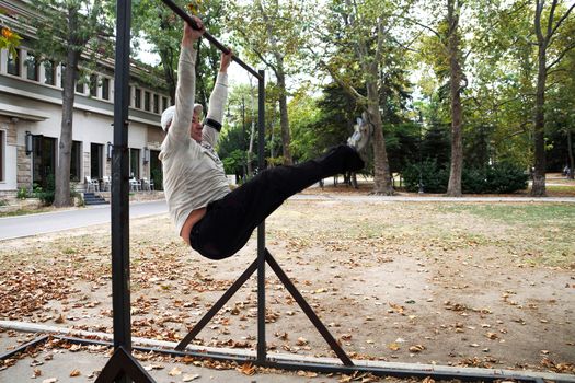 man is engaged on a horizontal bar in the park.