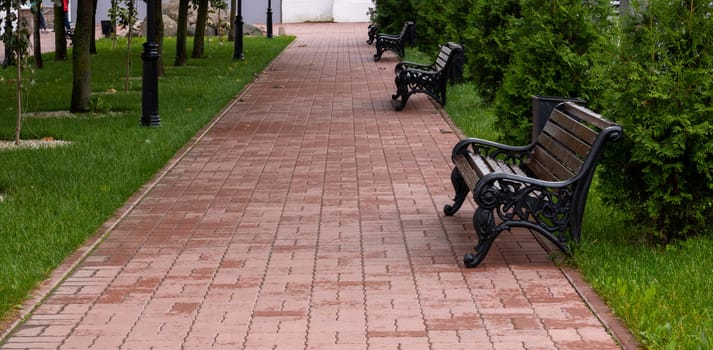 Red brick alley with brown benches.