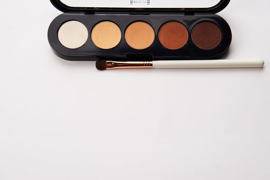 eyeshadows on isolated background and makeup brushes professional cosmetics. High quality photo