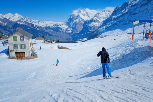 Skier skiing downhill in high mountains Kleine Scheidegg station at Switzerland