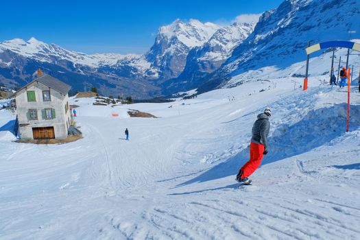 Skier skiing downhill in high mountains Kleine Scheidegg station at Switzerland