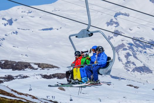Skier sitting at ski chair lift in high mountains in Switzerland