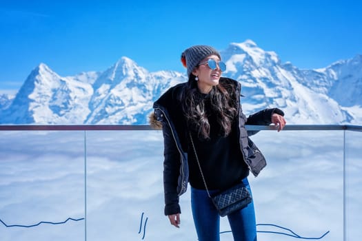Young Woman Tourist at the Schilthorn in Switzerland with a magnificent panoramic view of the Swiss Skyline. 
