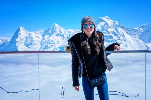 Young Woman Tourist at the Schilthorn in Switzerland with a magnificent panoramic view of the Swiss Skyline. 